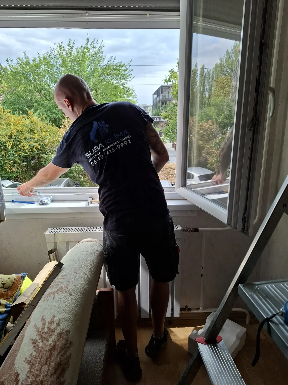 Klímaszerelés ablaknál, Suba Klíma feliratos pólóban
